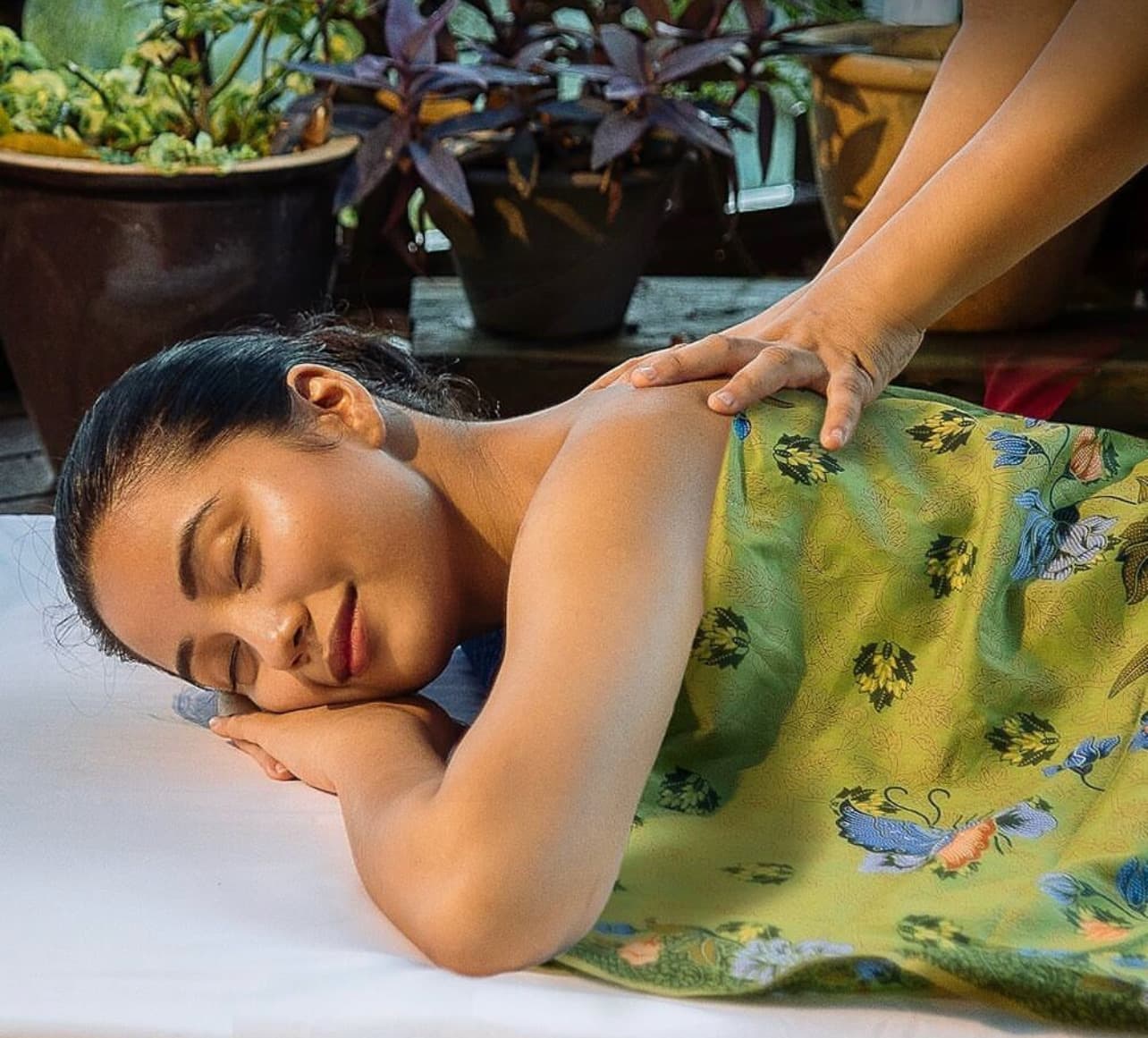 A therapist massaging a new mother's back at home